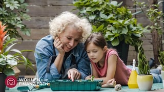 Oma und Enkelin schauen sich ihre wachsenden Kräuter an